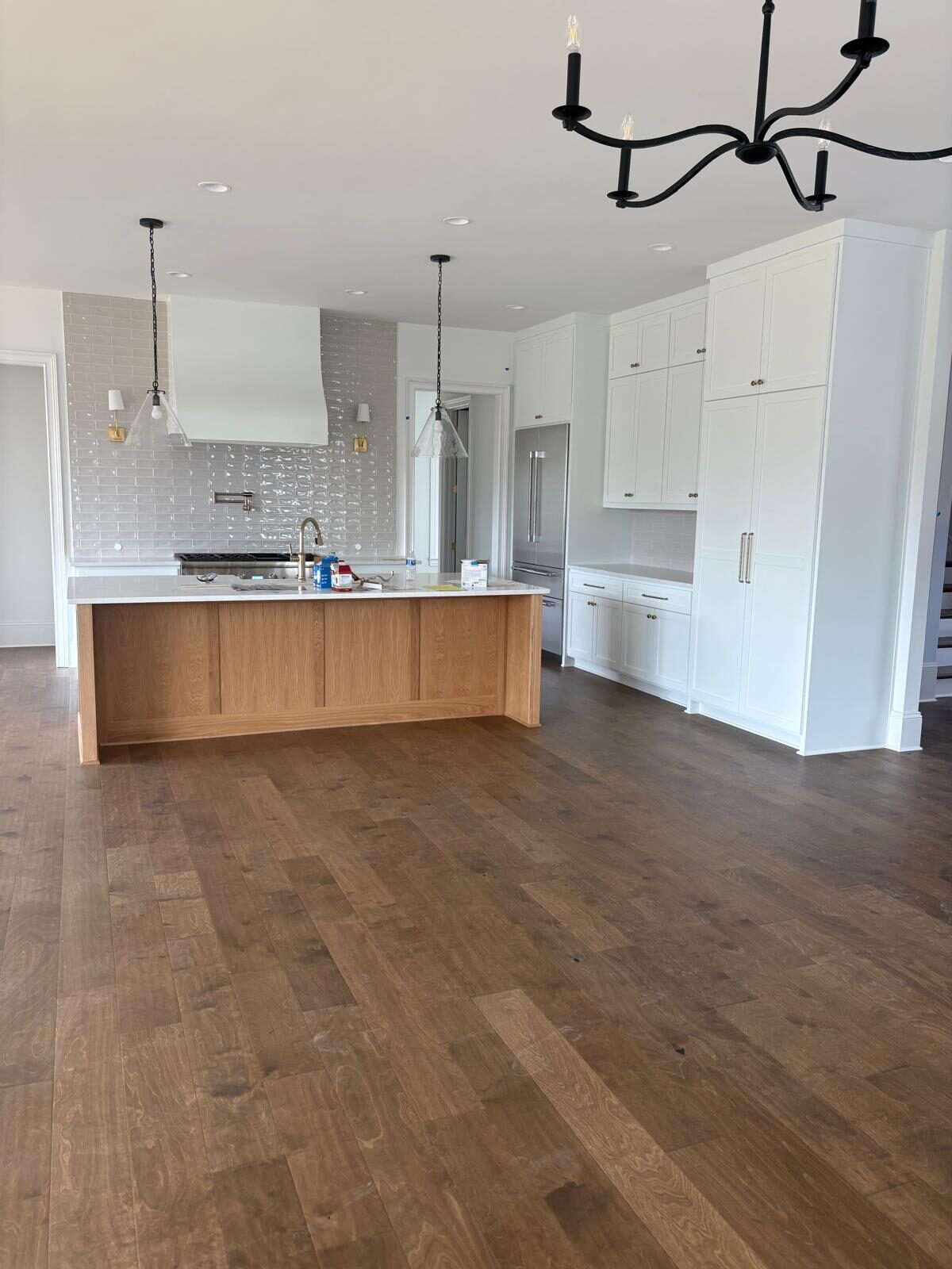 Bright white custom kitchen with a wood island and pendant lighting