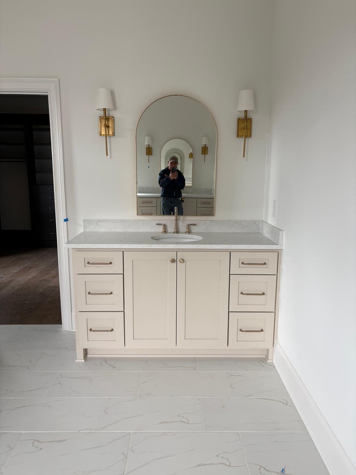 White shaker bathroom vanity with an arched mirror niche