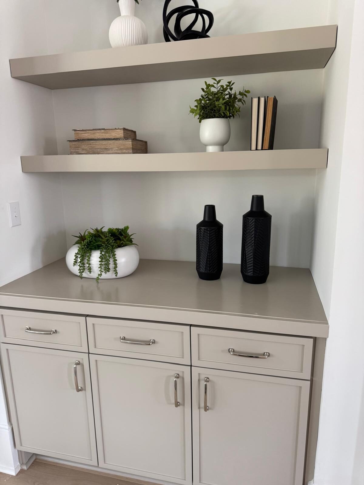 Styled floating shelves over custom base cabinets