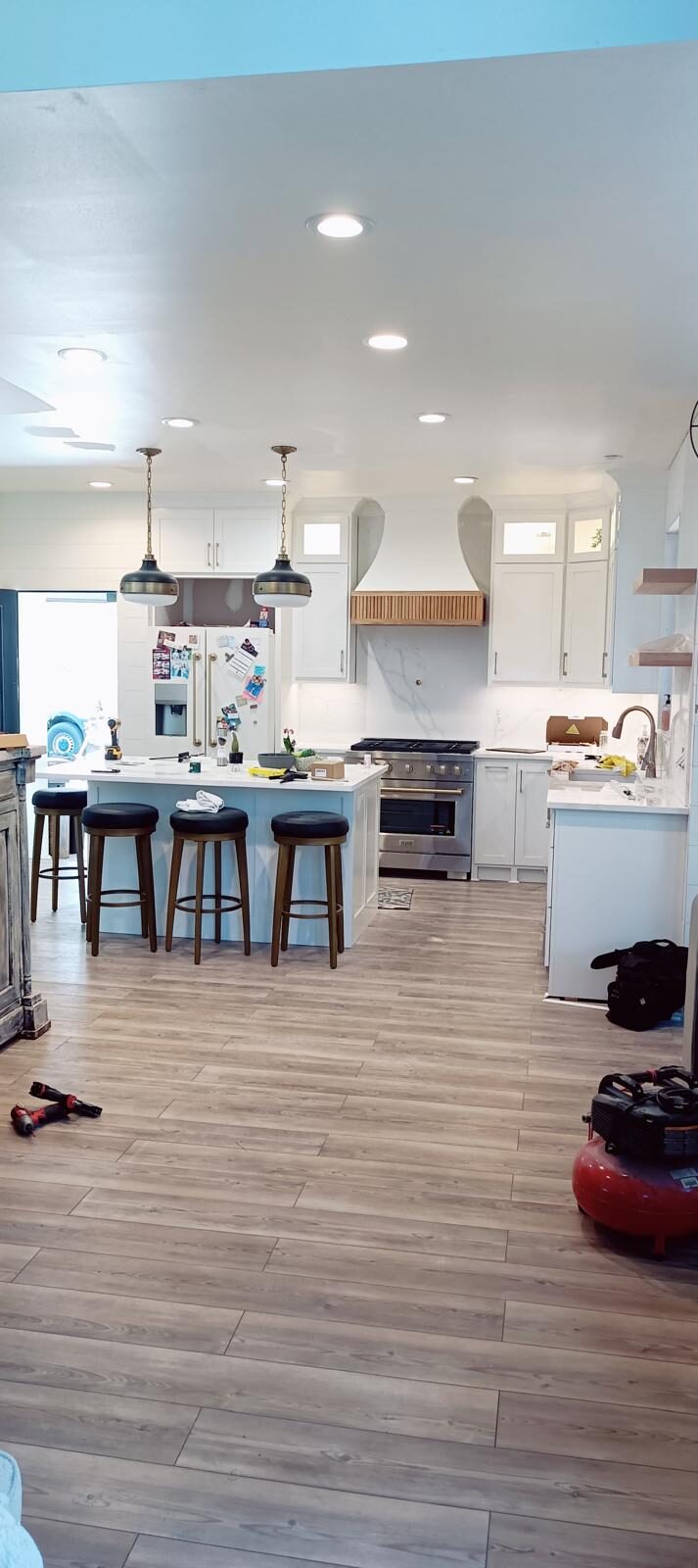 Open-concept white kitchen with an island and bar seating