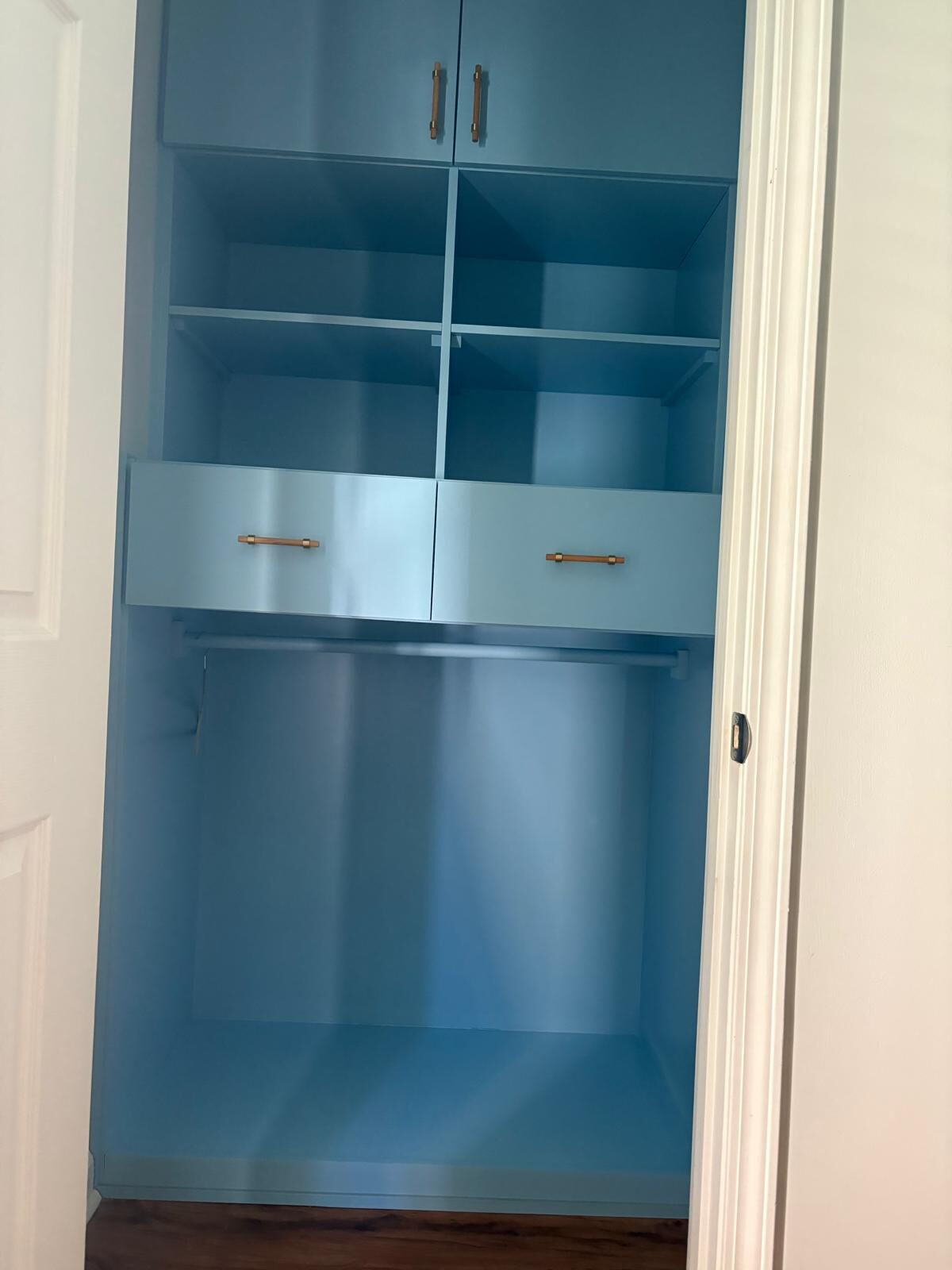 Blue glass-front display cabinet built into a hallway